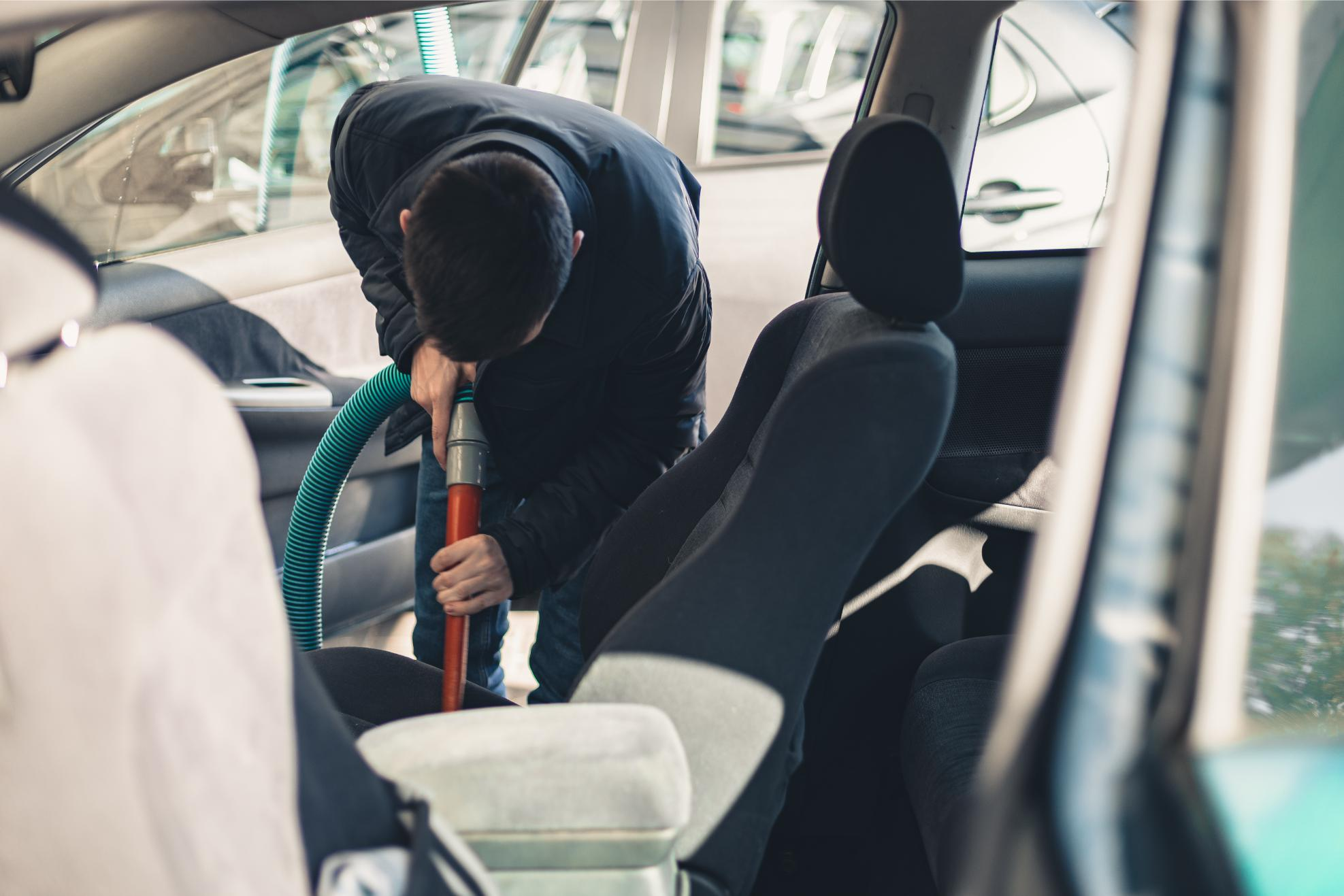a young man vacuums the interior of a car 2025 03 09 09 19 55 utc